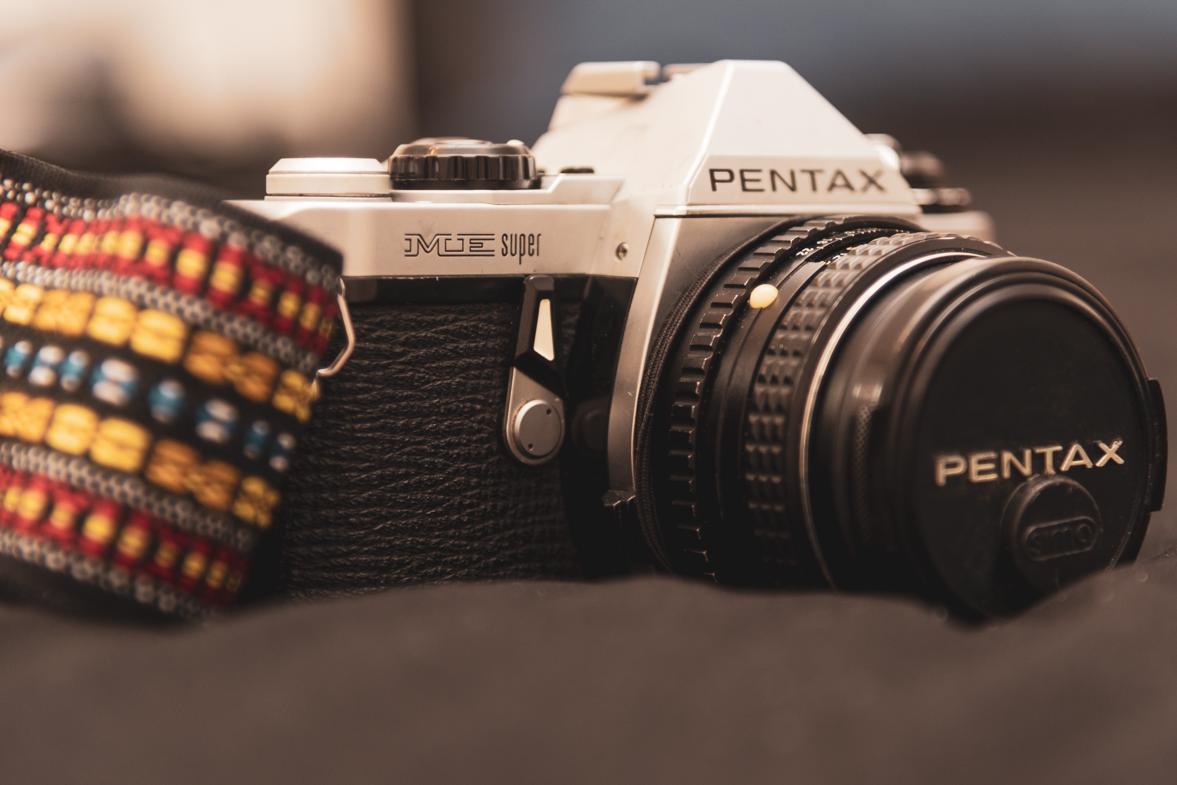 Close-up photo of a Pentax ME Super, a 35mm film SLR camera, with a lens attached.